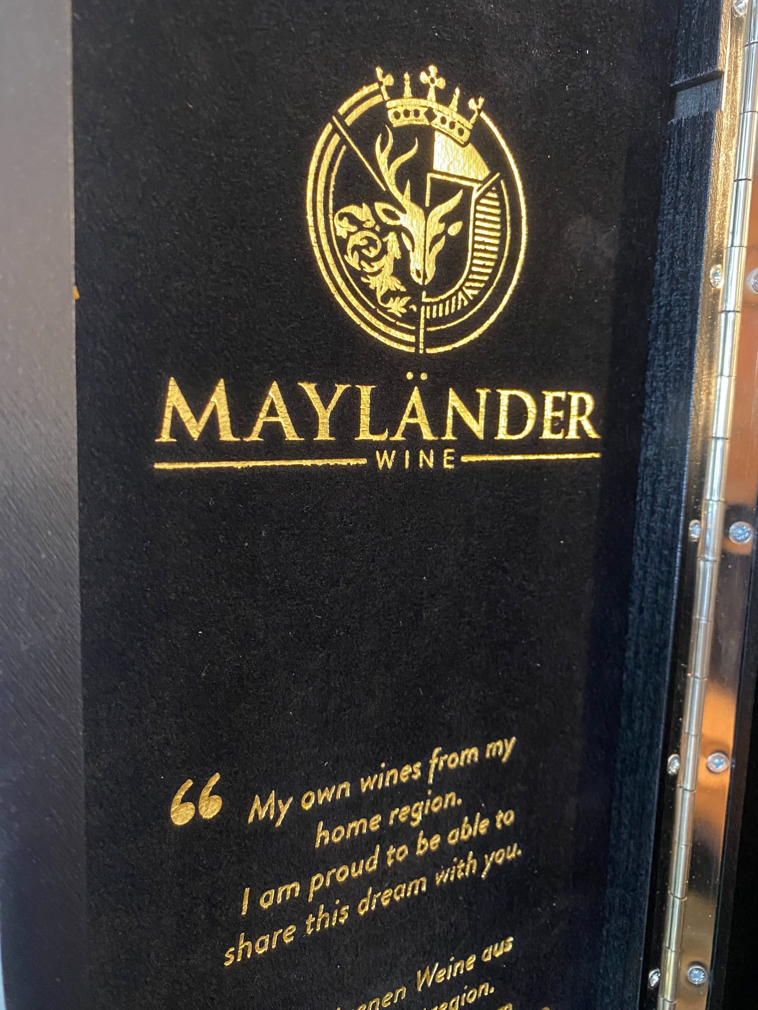 Mayländer Wine logo on a black background with gold lettering and emblem.